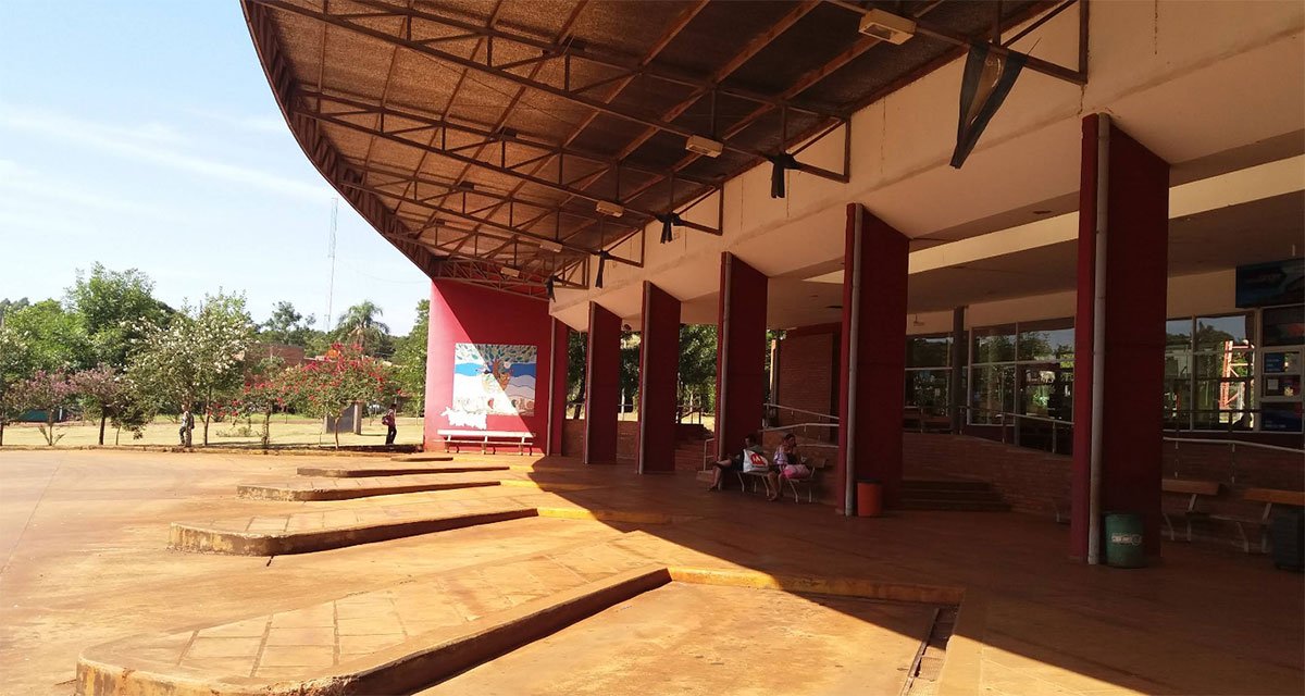 Galería de la Terminal de Ómnibus de Montecarlo, Misiones, con techo curvo, columnas bordó y boleterías vidriadas